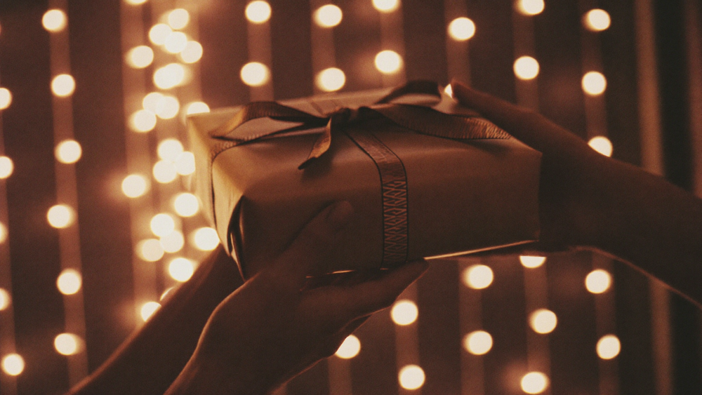 Hands holding a thoughtfully wrapped birthday gift